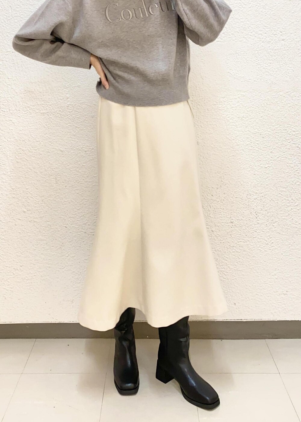 ブラック系のダウンジャケット/コート、ブラック系のブーツ、グレー系のニット/セーターを着用したレディースの冬コーディネートの6枚目の写真