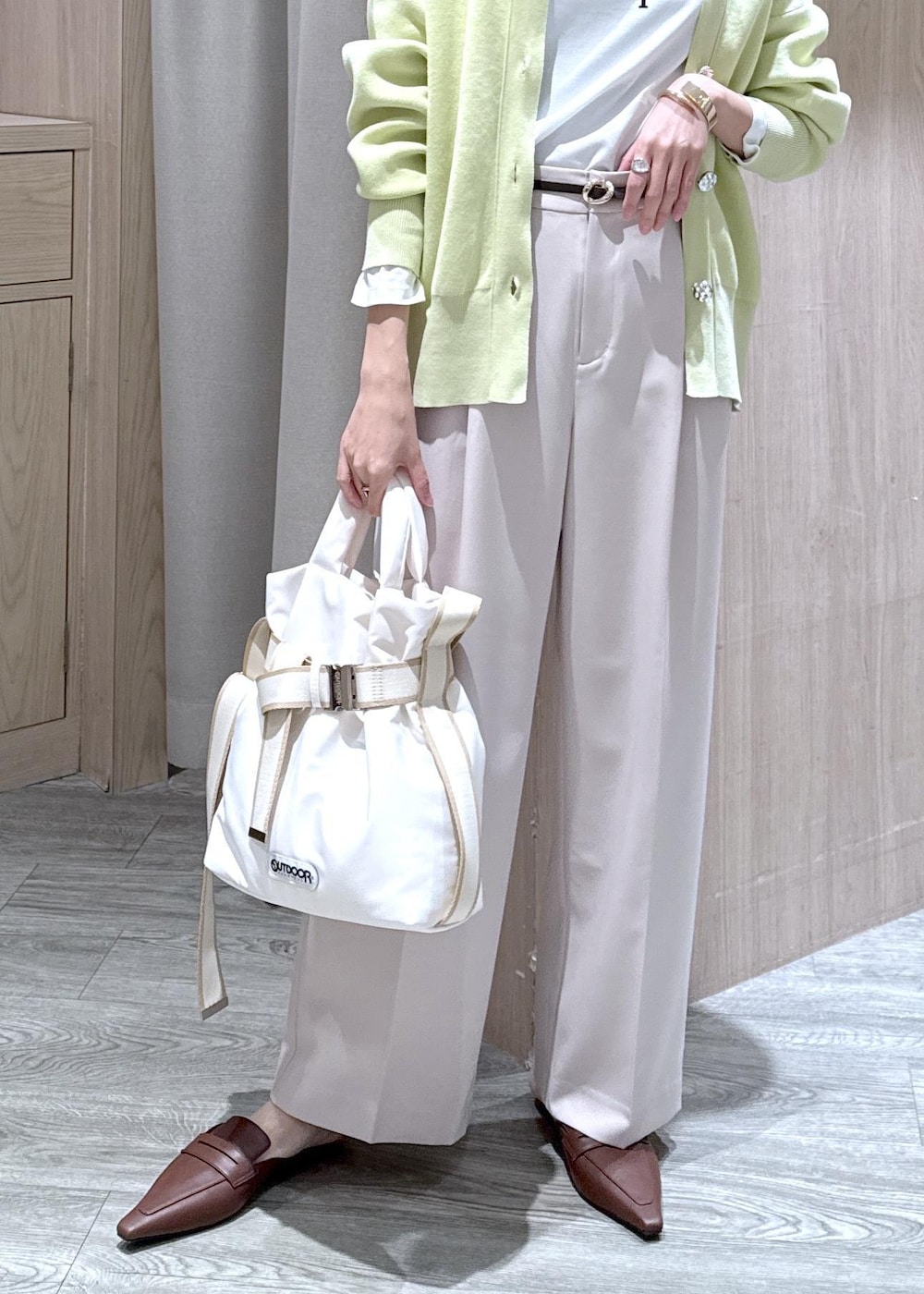 ホワイト系のTシャツ/カットソー、ベージュ系のその他パンツ、グリーン系のカーディガン/ボレロを着用したレディースの冬コーディネートの10枚目の写真