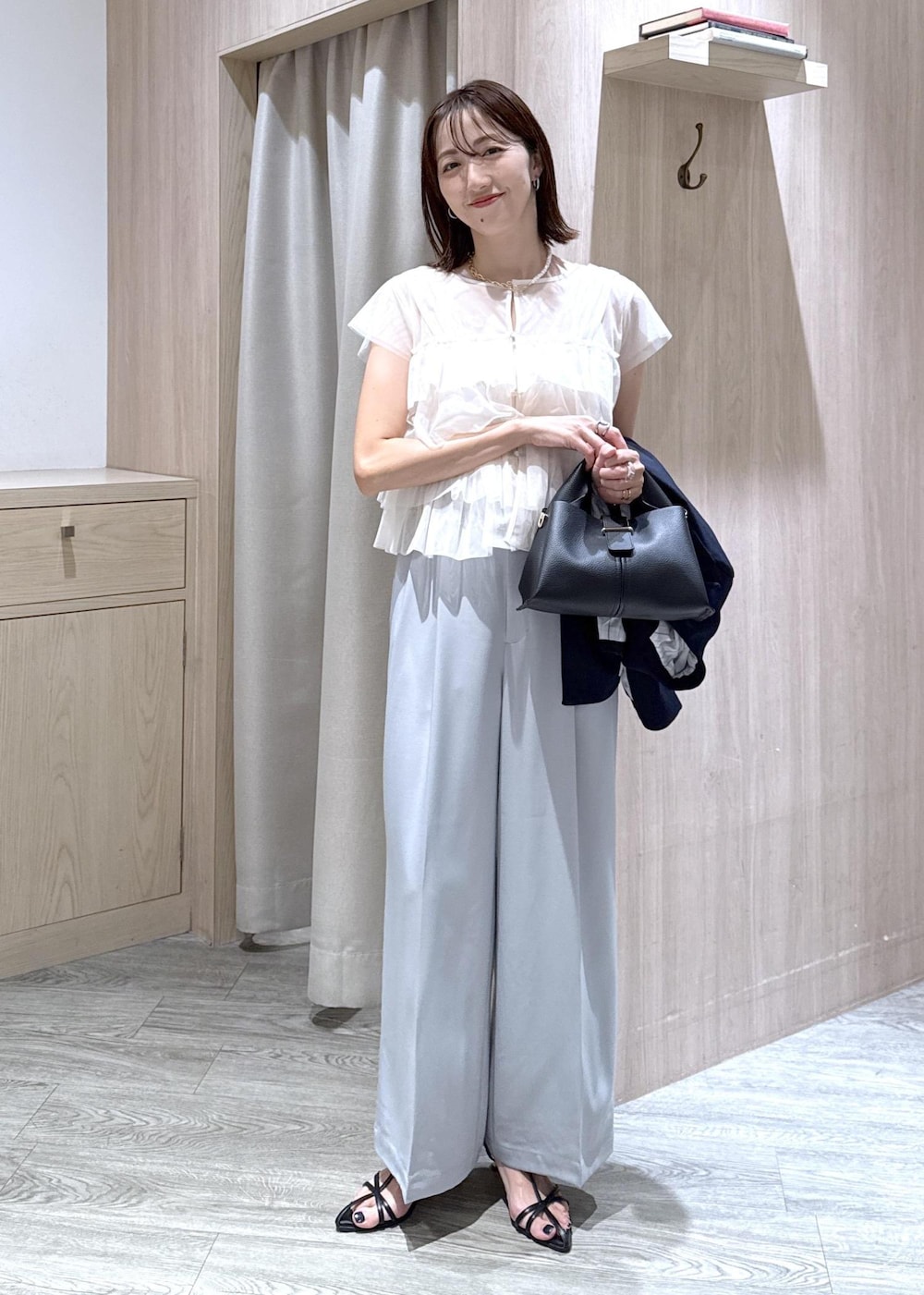 ブラック系のショルダーバッグ、ブルー系のその他パンツ、ホワイト系のTシャツ/カットソーを着用したレディースの秋コーディネートの7枚目の写真