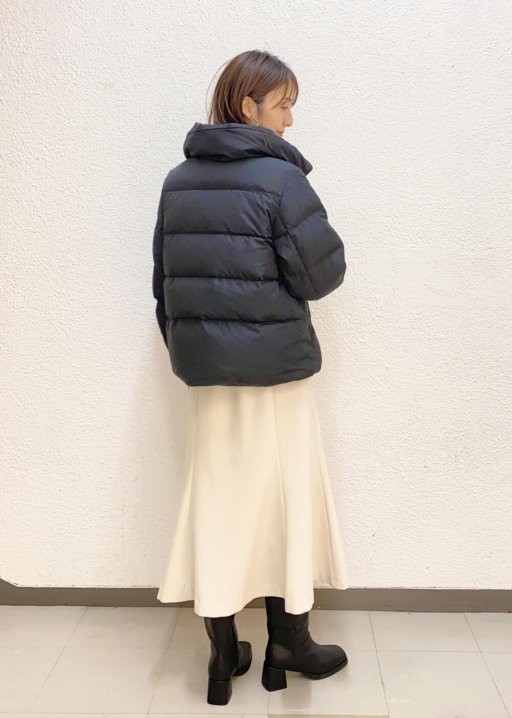 ブラック系のダウンジャケット/コート、ブラック系のブーツ、グレー系のニット/セーターを着用したレディースの冬コーディネートの3枚目の写真