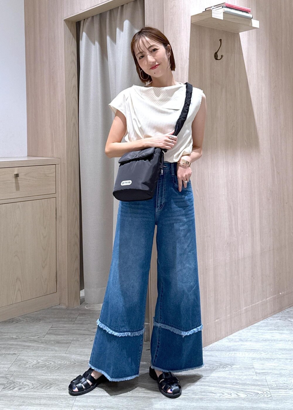 ベージュ系のキャミソール、ベージュ系のシャツ/ブラウス、ブルー系のデニムパンツを着用したレディースの夏コーディネートの2枚目の写真