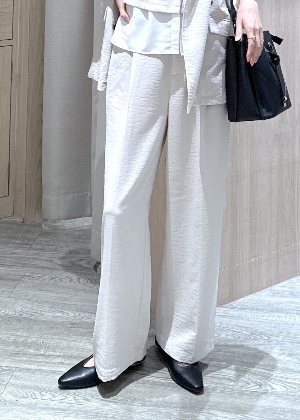 ブラック系のショルダーバッグ、ブラック系のパンプス、ホワイト系のシャツ/ブラウスを着用したレディースの春コーディネートの5枚目の写真