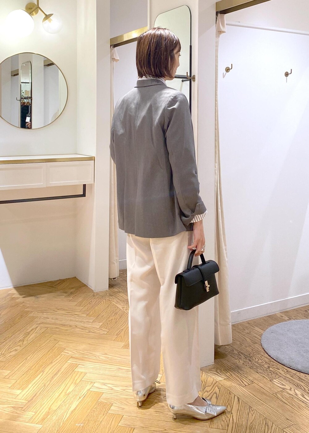 シルバー系のパンプス、ホワイト系のシャツ/ブラウス、ホワイト系のスラックスを着用したレディースの冬コーディネートの3枚目の写真