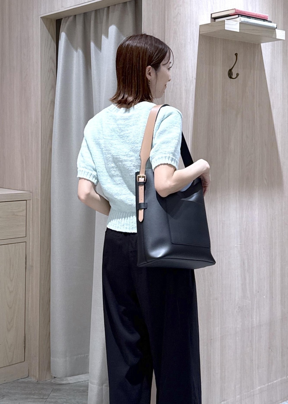 ブラック系のトートバッグ、ブラック系のその他パンツ、グリーン系のニット/セーターを着用したレディースの夏コーディネートの3枚目の写真