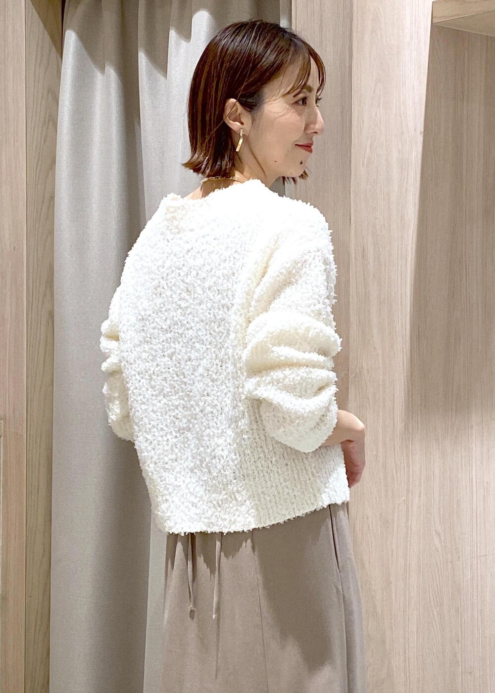 ホワイト系のブーツ、ベージュ系のスカート、ホワイト系のカーディガン/ボレロを着用したレディースの冬コーディネートの9枚目の写真