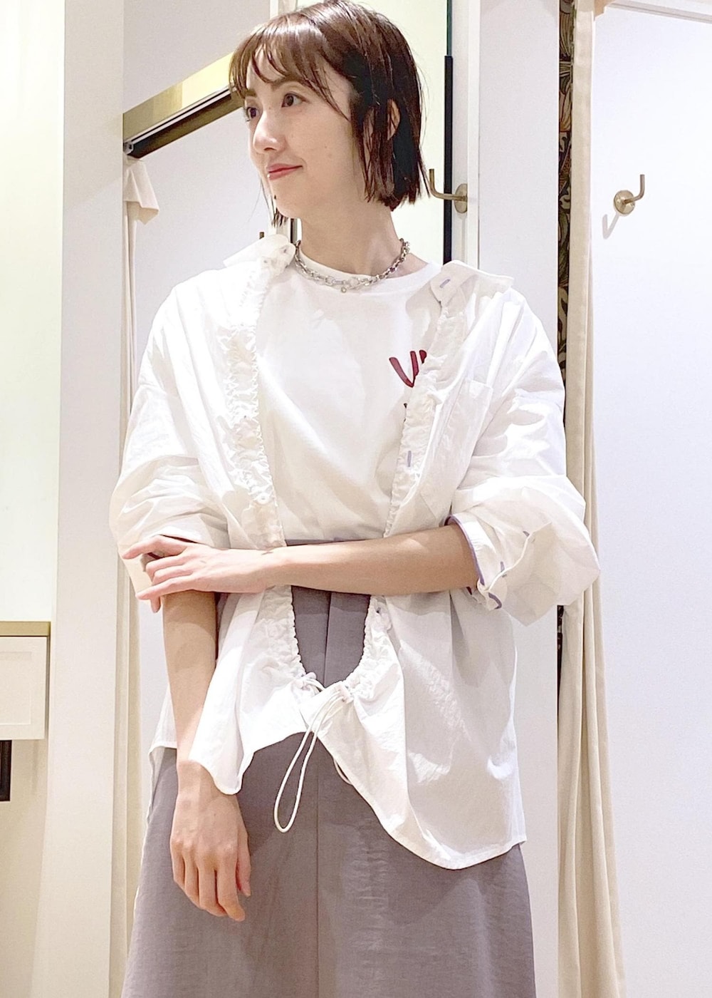 グレー系のスカート、ホワイト系のブルゾン、ホワイト系のTシャツ/カットソーを着用したレディースの春コーディネートの3枚目の写真