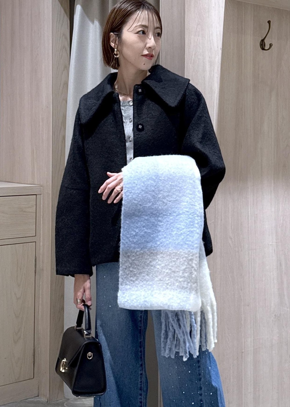 グレー系のカーディガン/ボレロ、ブラック系のブルゾン、ブルー系のデニムパンツを着用したレディースの秋コーディネートの10枚目の写真