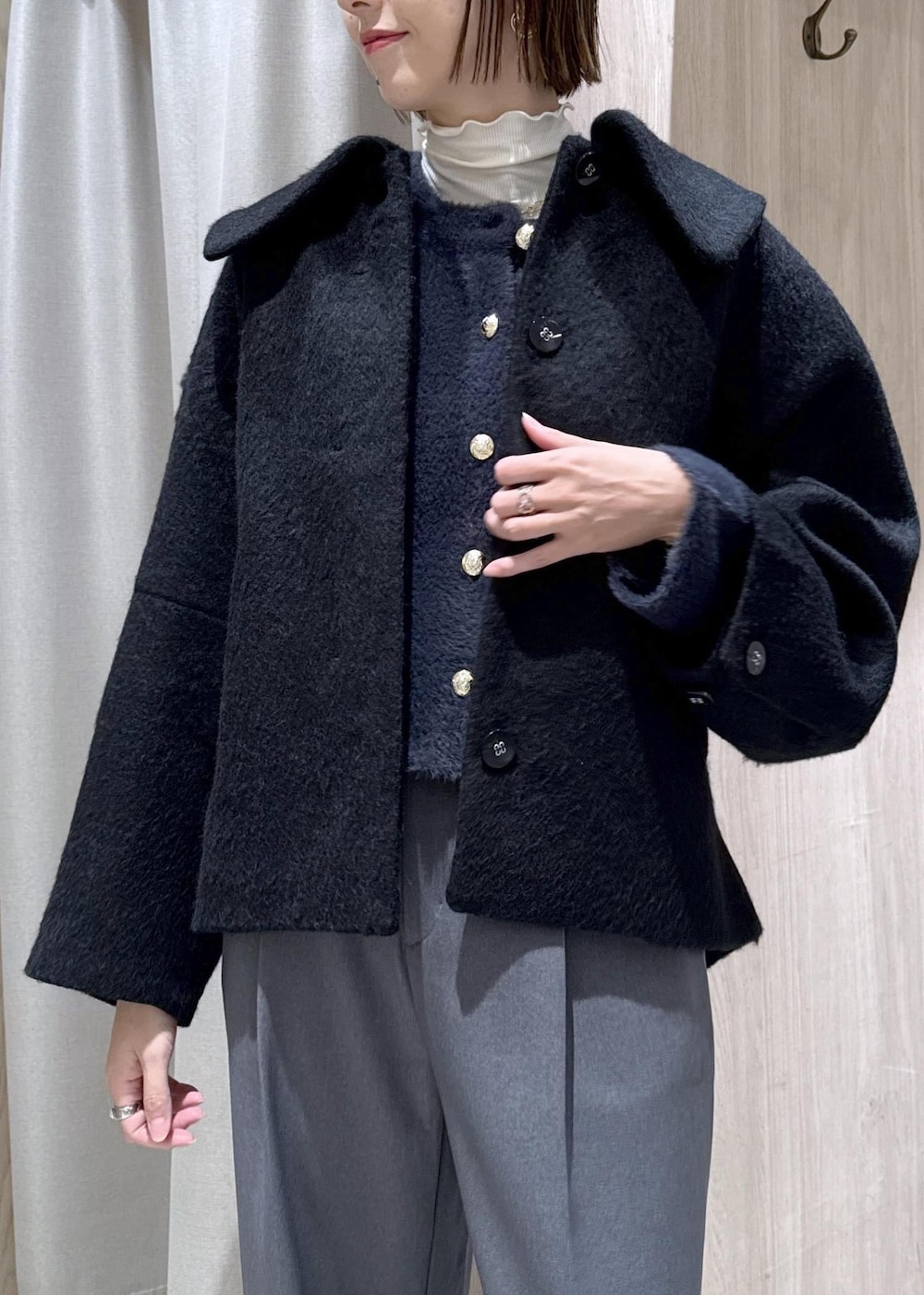 ホワイト系のショルダーバッグ、ブラック系のローファー、ブルー系のカーディガン/ボレロを着用したレディースの冬コーディネートの7枚目の写真