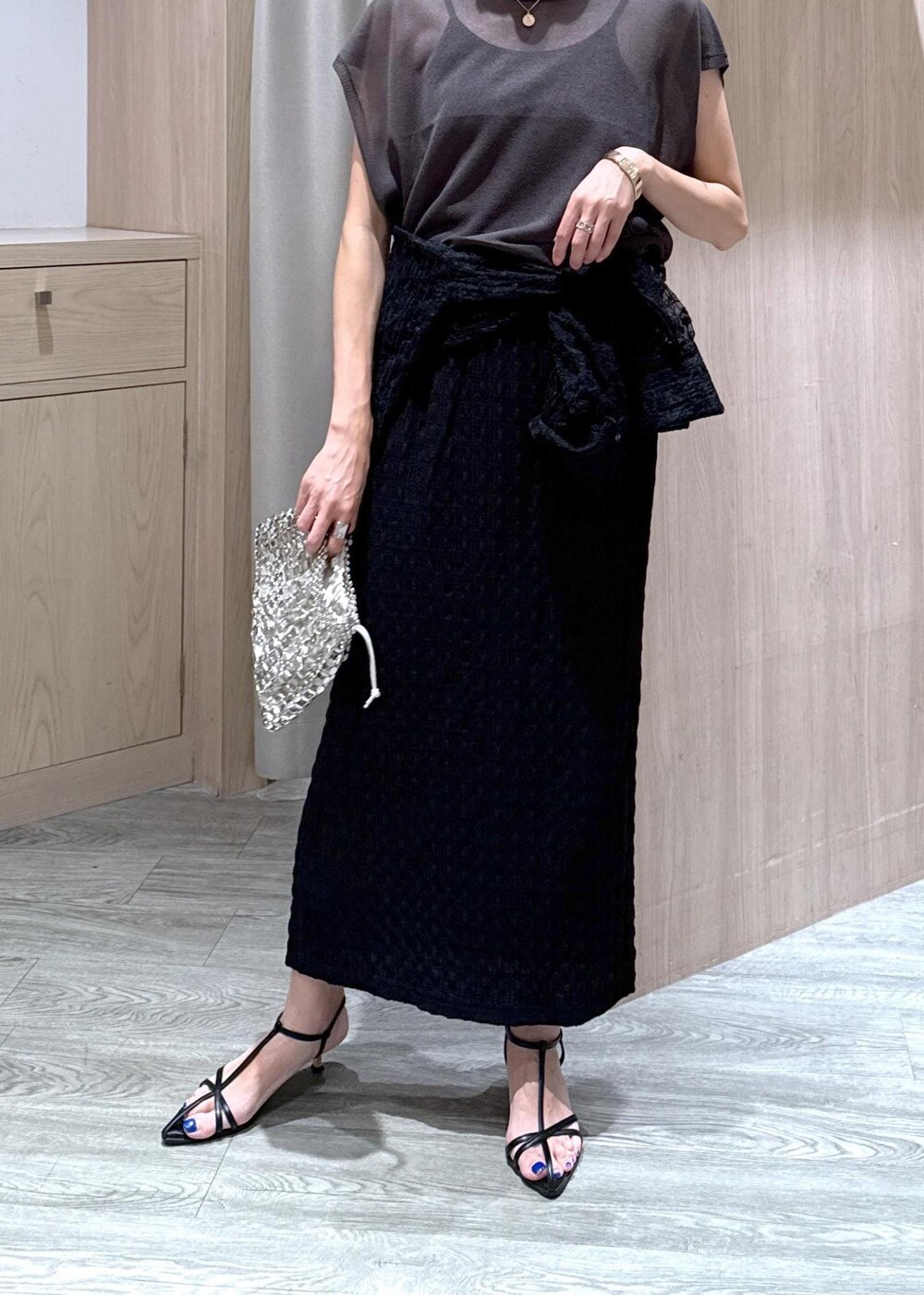 ブラック系のサンダル、シルバー系のハンドバッグ、ブラック系のシャツ/ブラウスを着用したレディースの夏コーディネートの6枚目の写真