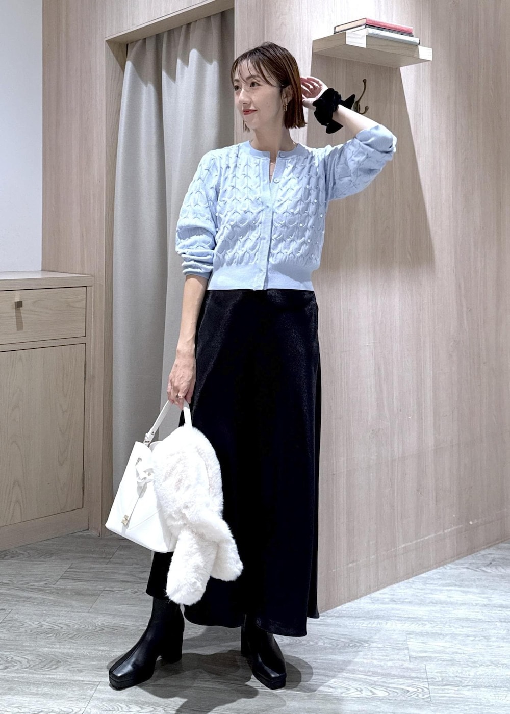 ホワイト系のショルダーバッグ、ホワイト系のキャミソール、ブラック系のブーツを着用したレディースの秋コーディネートの4枚目の写真