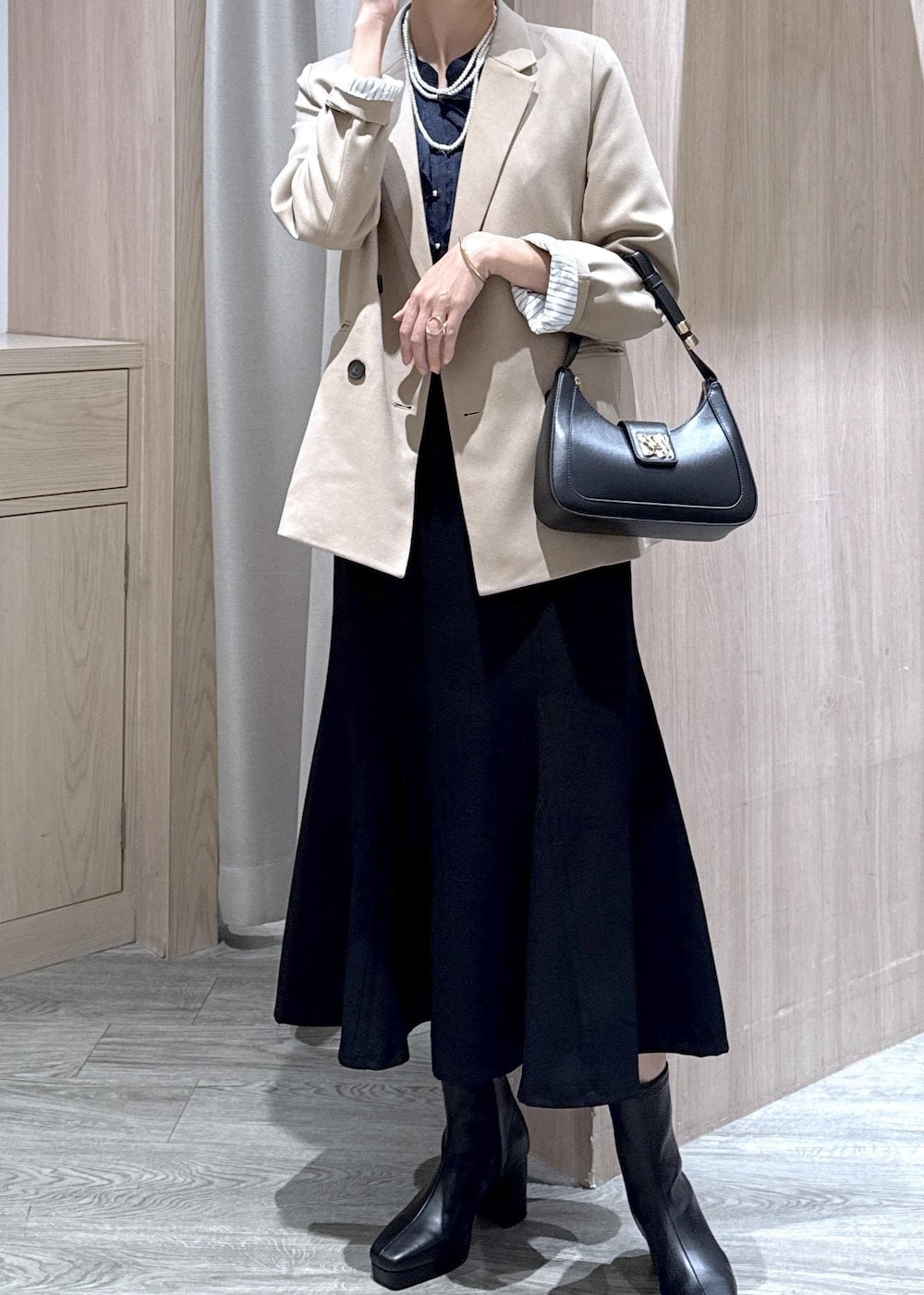 ブラック系のハンドバッグ、ブルー系のシャツ/ブラウス、ベージュ系のテーラードジャケットを着用したレディースの秋コーディネートの2枚目の写真