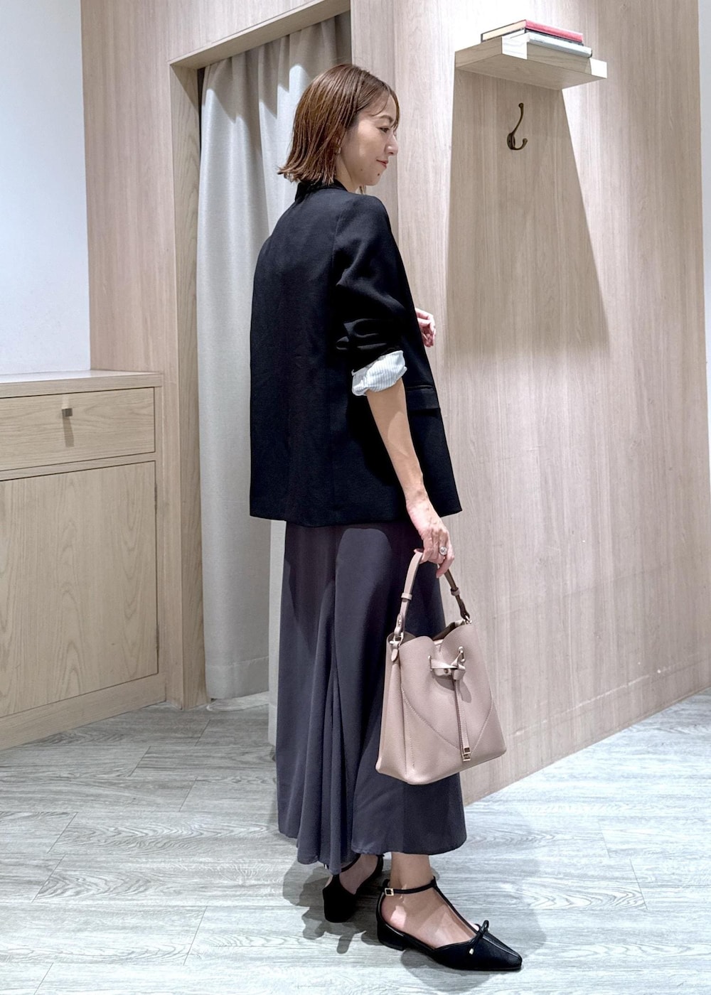 ブラック系のパンプス、ブラック系のテーラードジャケット、ベージュ系のショルダーバッグを着用したレディースの秋コーディネートの4枚目の写真