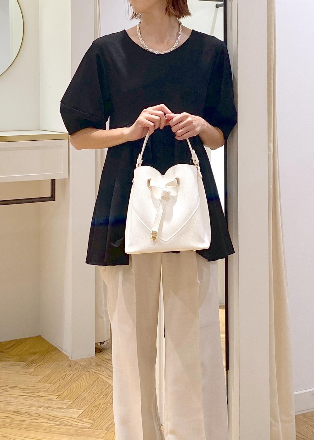 ホワイト系のショルダーバッグ、ホワイト系のスラックス、ブラック系のバレエシューズを着用したレディースの秋コーディネートの5枚目の写真