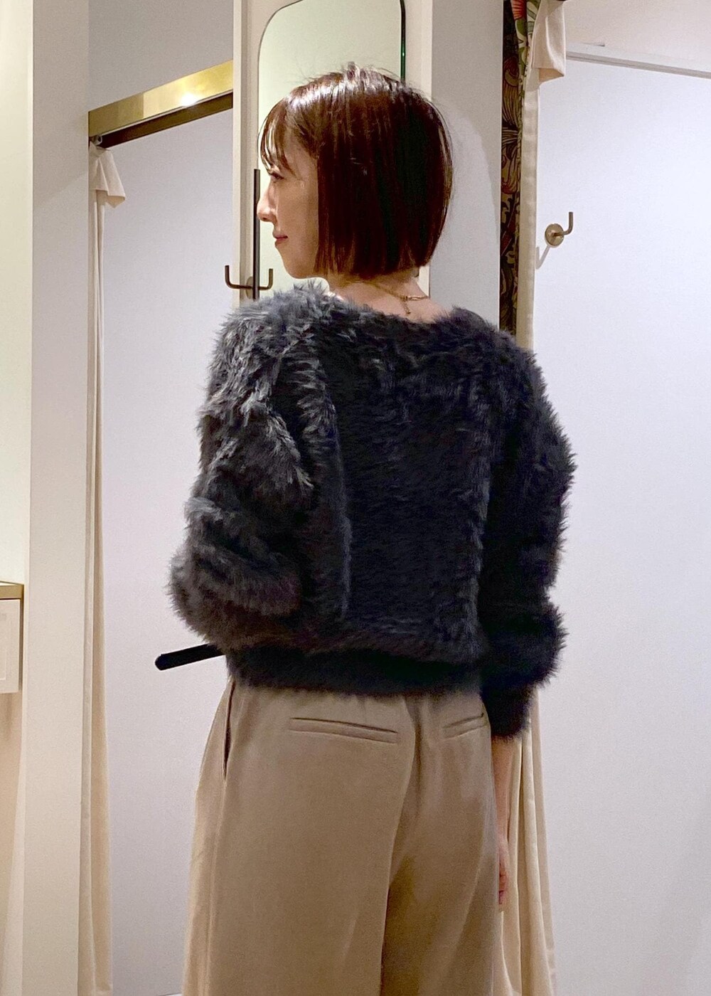 レッド系のトートバッグ、ベージュ系のスラックス、グレー系のカーディガン/ボレロを着用したレディースの冬コーディネートの8枚目の写真