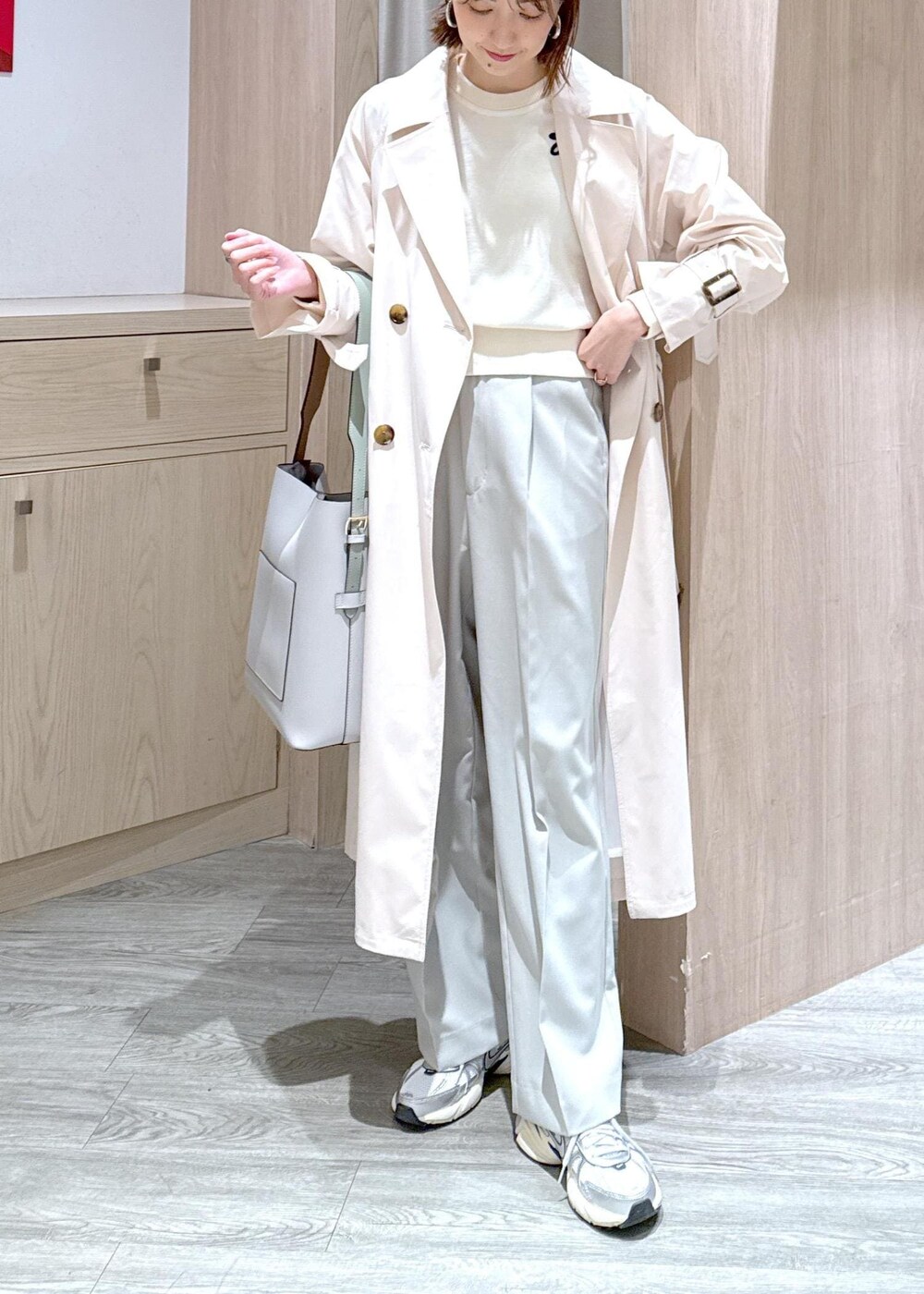 ホワイト系のニット/セーター、ホワイト系のトレンチコート、グリーン系のスラックスを着用したレディースの冬コーディネートの7枚目の写真