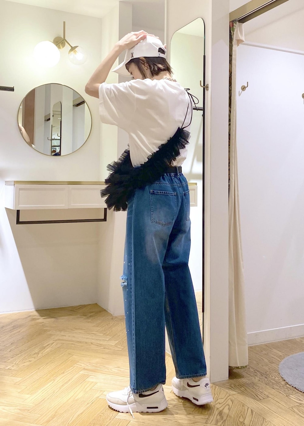 ブルー系のデニムパンツ、ブラック系のショルダーバッグ、ホワイト系のTシャツ/カットソーを着用したレディースの春コーディネートの2枚目の写真