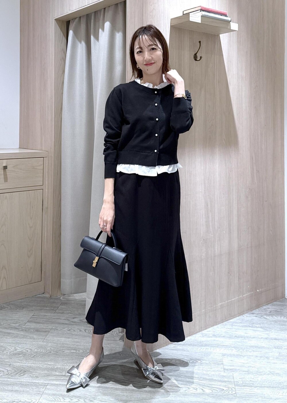 シルバー系のパンプス、ブラック系のショルダーバッグ、ブラック系のスカートを着用したレディースの冬コーディネートの3枚目の写真