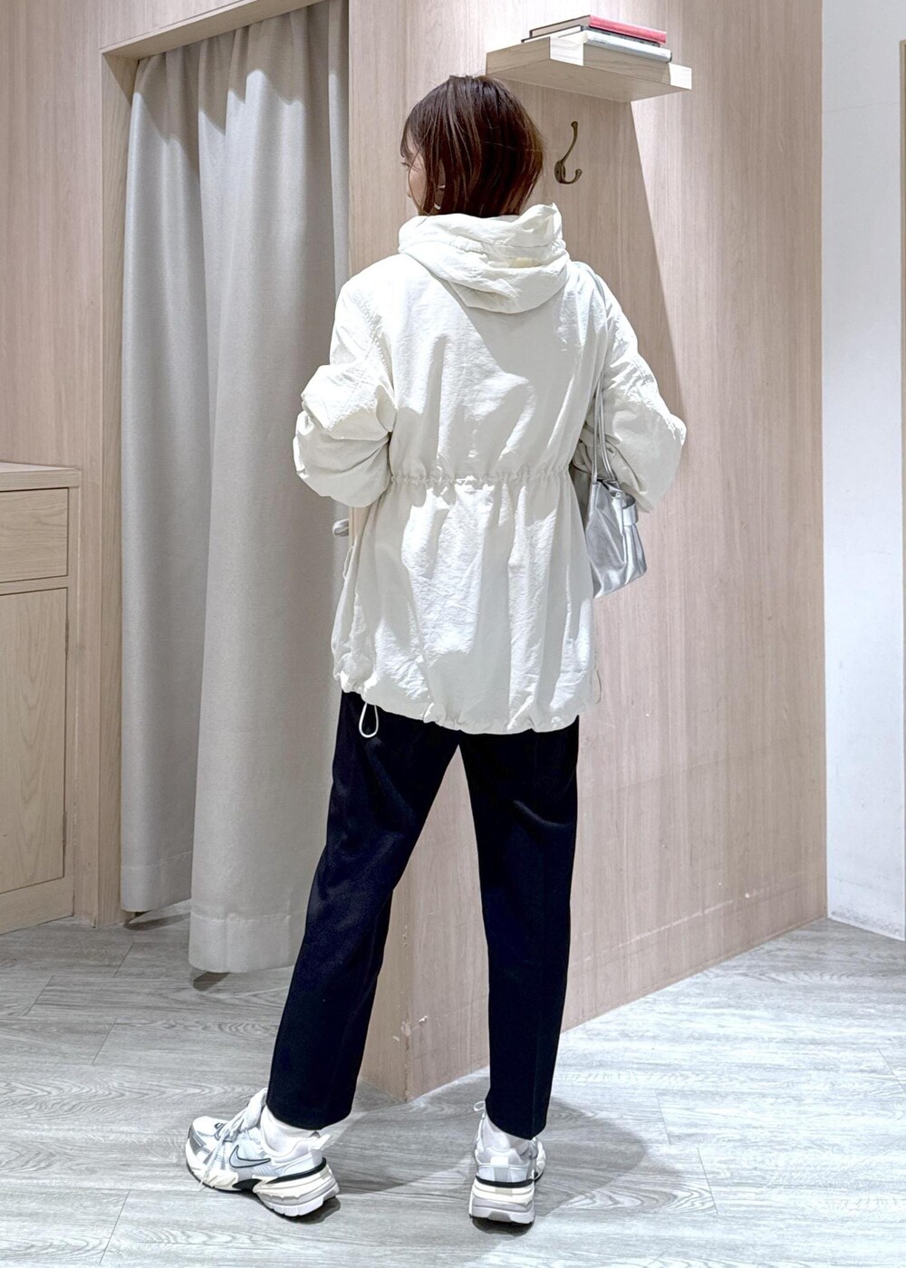 シルバー系のショルダーバッグ、ブラック系のその他パンツ、ホワイト系のマウンテンパーカーを着用したレディースの冬コーディネートの4枚目の写真