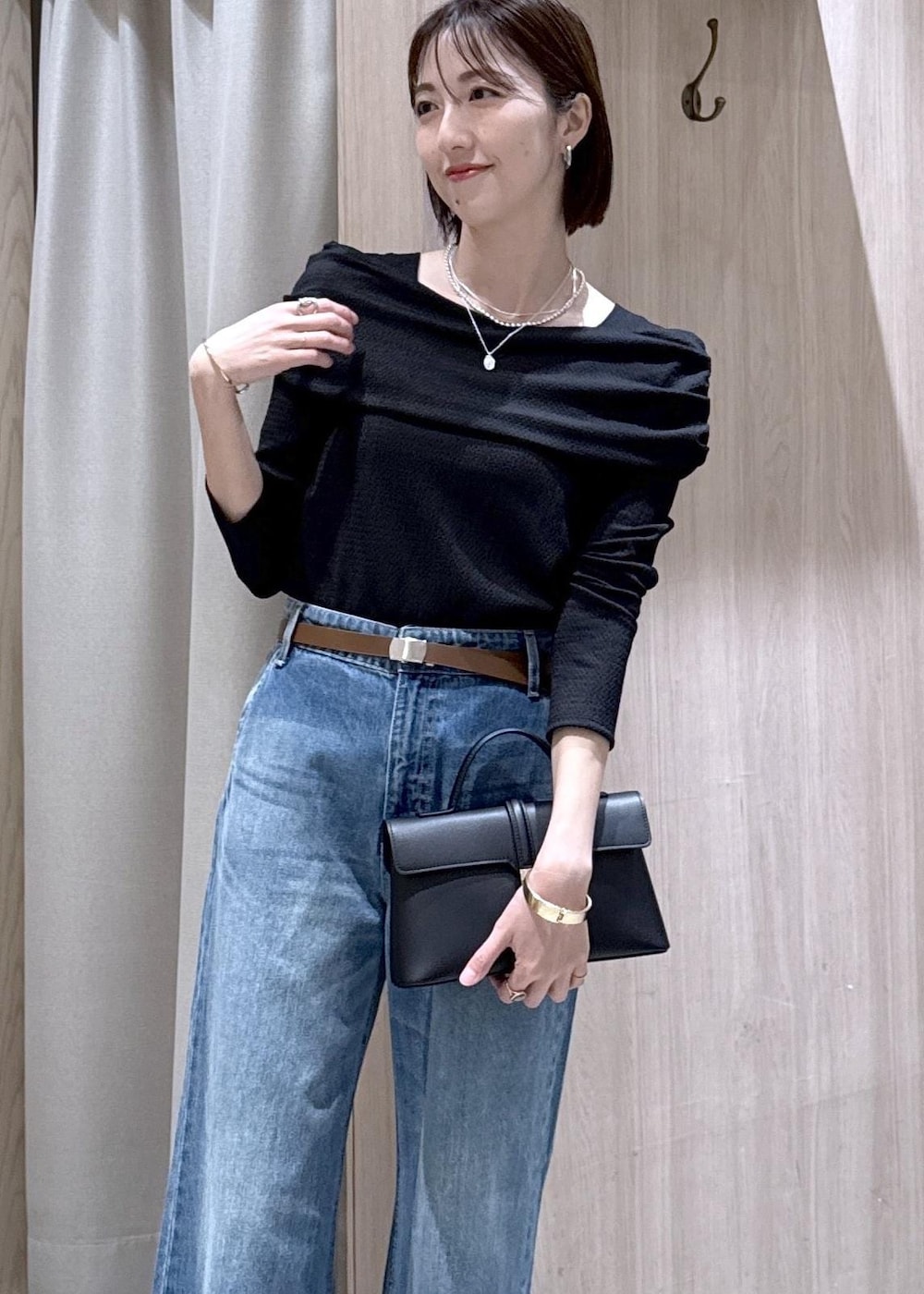 ブラック系のショルダーバッグ、ブルー系のデニムパンツ、ブラック系のTシャツ/カットソーを着用したレディースの春コーディネートの10枚目の写真