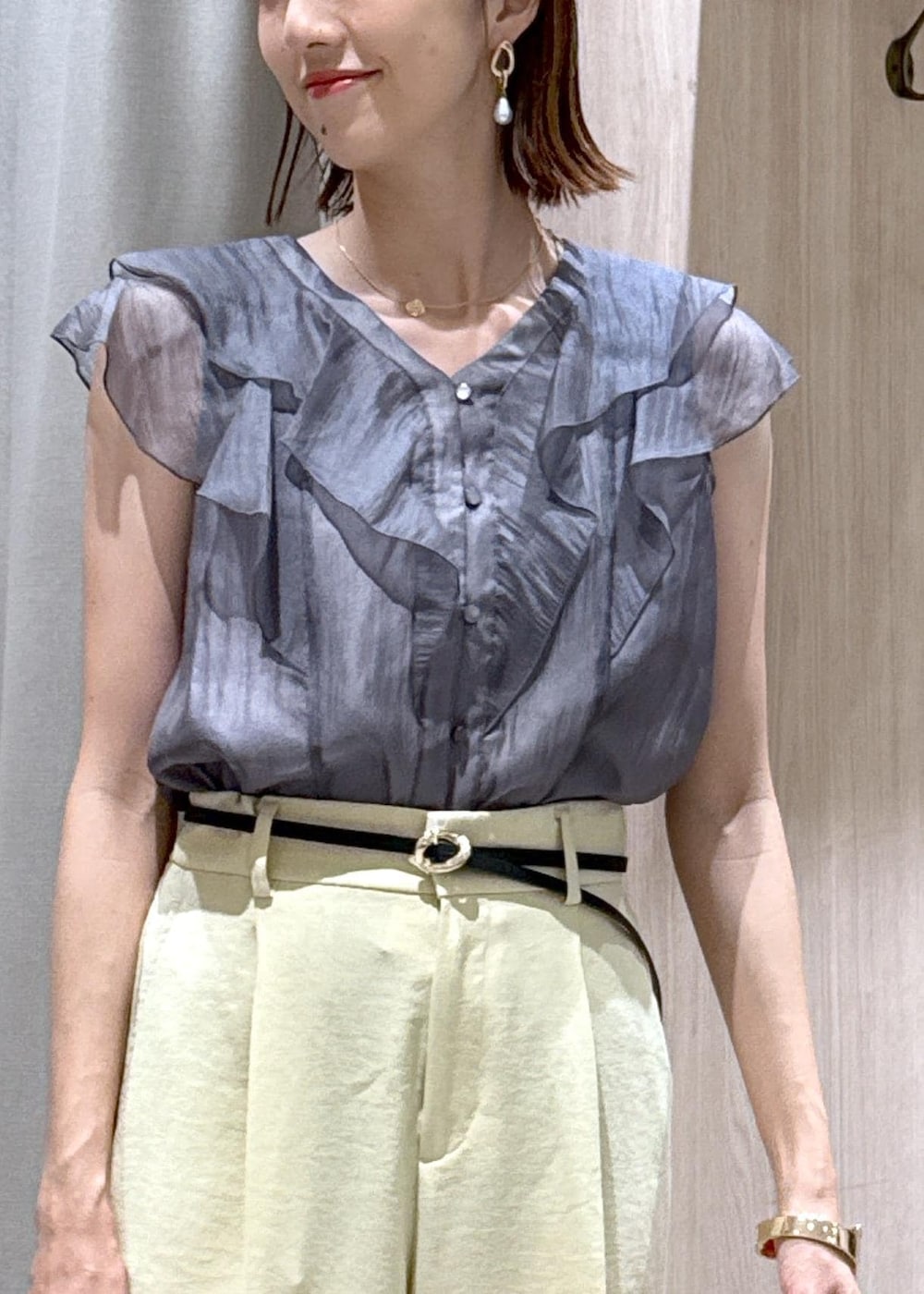 ホワイト系のショルダーバッグ、ホワイト系のサンダル、イエロー系のスラックスを着用したレディースの夏コーディネートの7枚目の写真