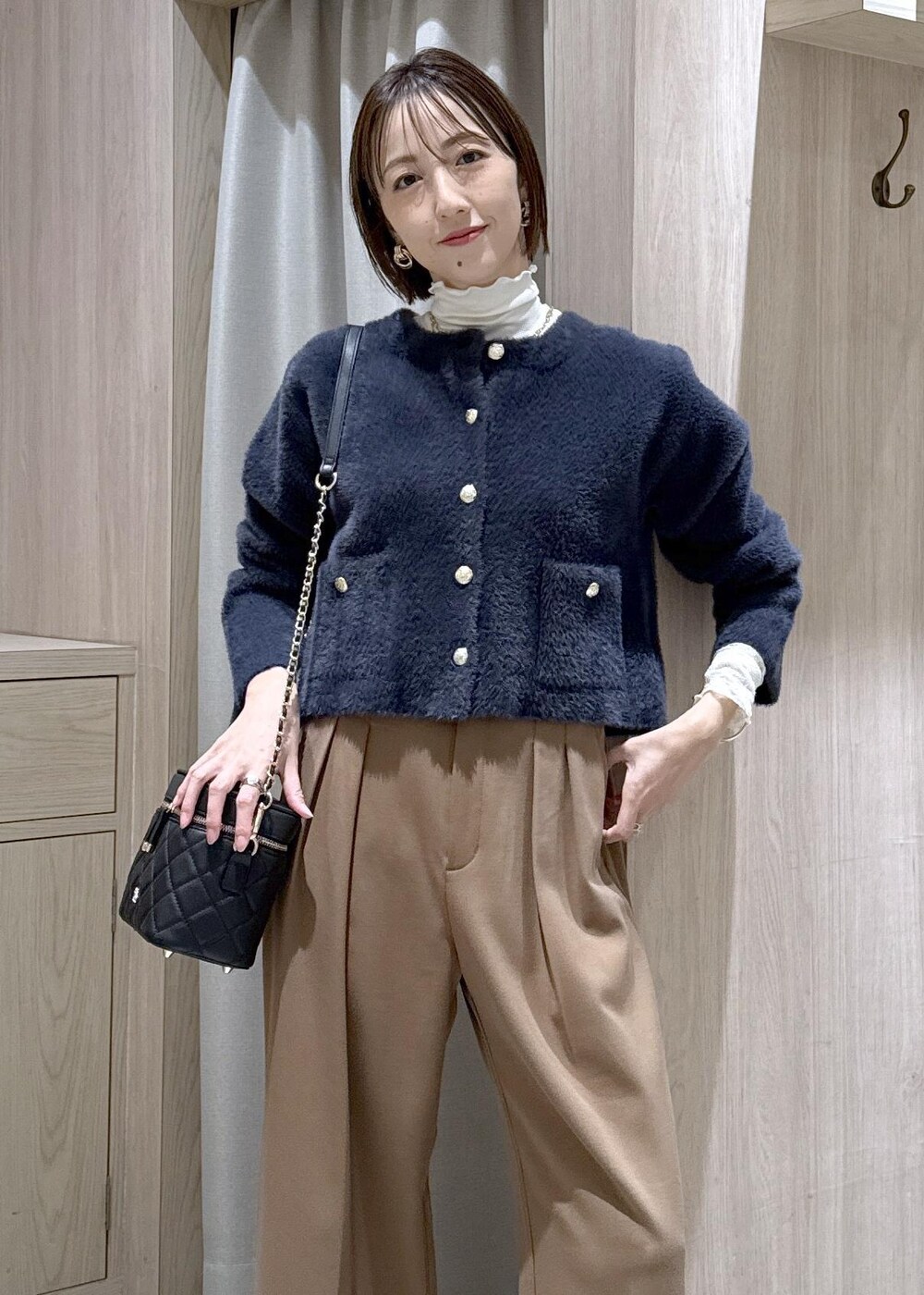 ブルー系のカーディガン/ボレロ、ホワイト系のTシャツ/カットソー、ブラック系のハンドバッグを着用したレディースの秋コーディネートの8枚目の写真