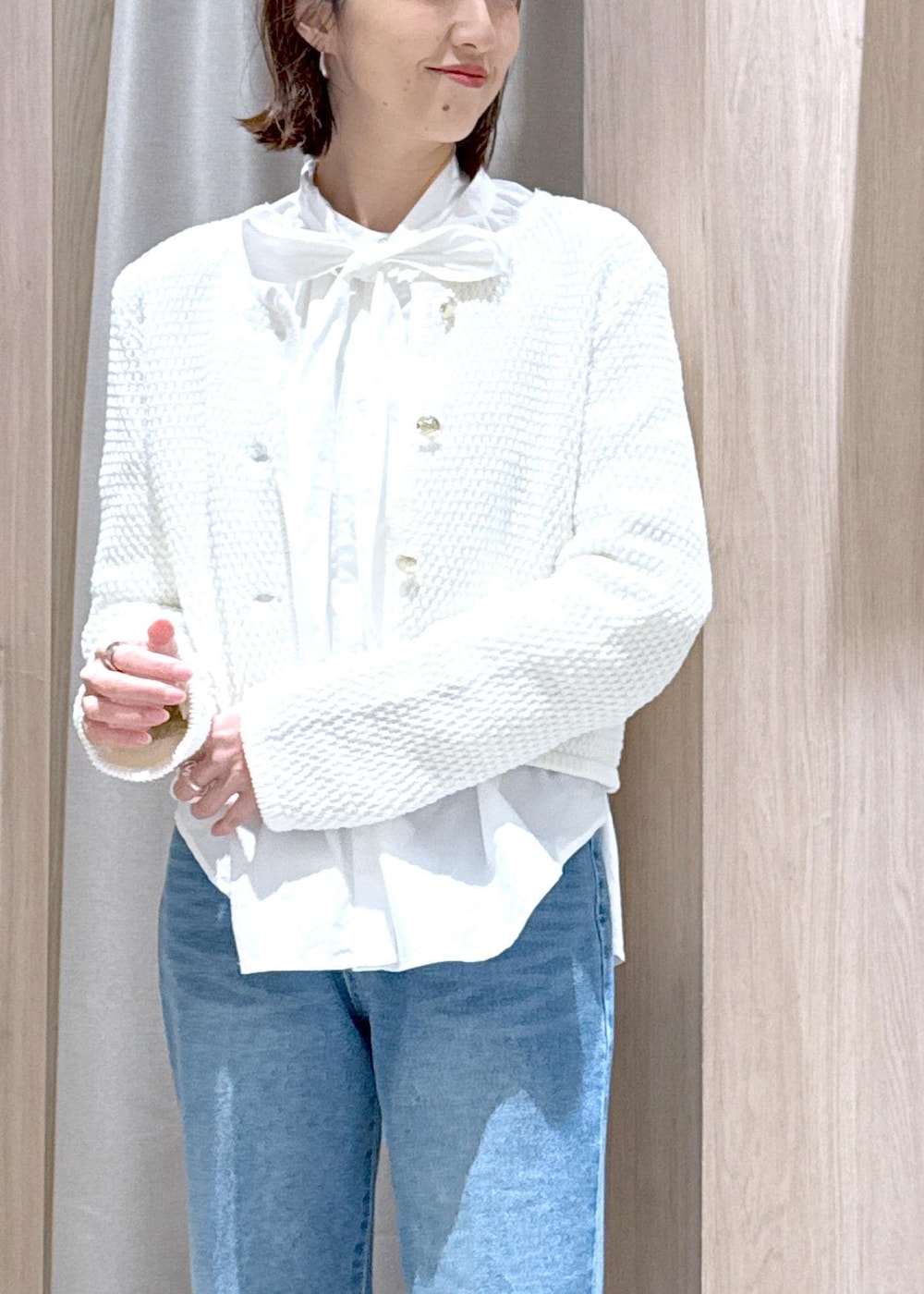 ブラック系のショルダーバッグ、ベージュ系のトレンチコート、ホワイト系のカーディガン/ボレロを着用したレディースの春コーディネートの8枚目の写真