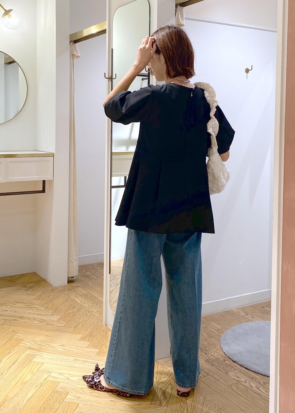 その他のサンダル、ブラック系のTシャツ/カットソー、ブルー系のデニムパンツを着用したレディースの秋コーディネートの2枚目の写真