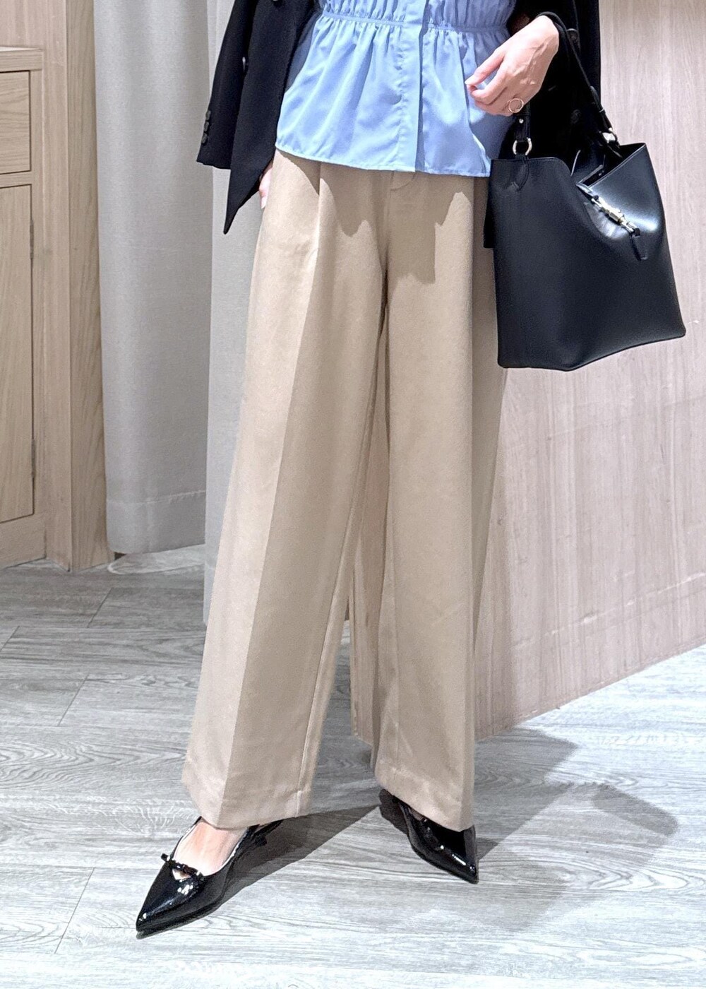 ブラック系のパンプス、ブラック系のトートバッグ、ブルー系のシャツ/ブラウスを着用したレディースの秋コーディネートの4枚目の写真