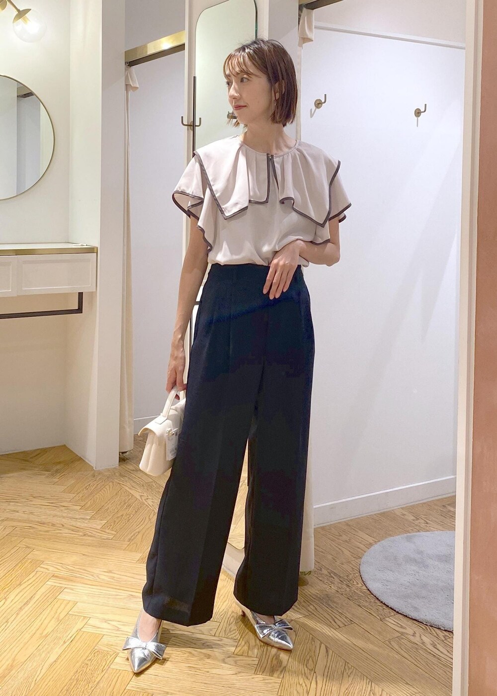 シルバー系のパンプス、ブラック系のキャミソール、ブルー系のスラックスを着用したレディースの夏コーディネートの8枚目の写真