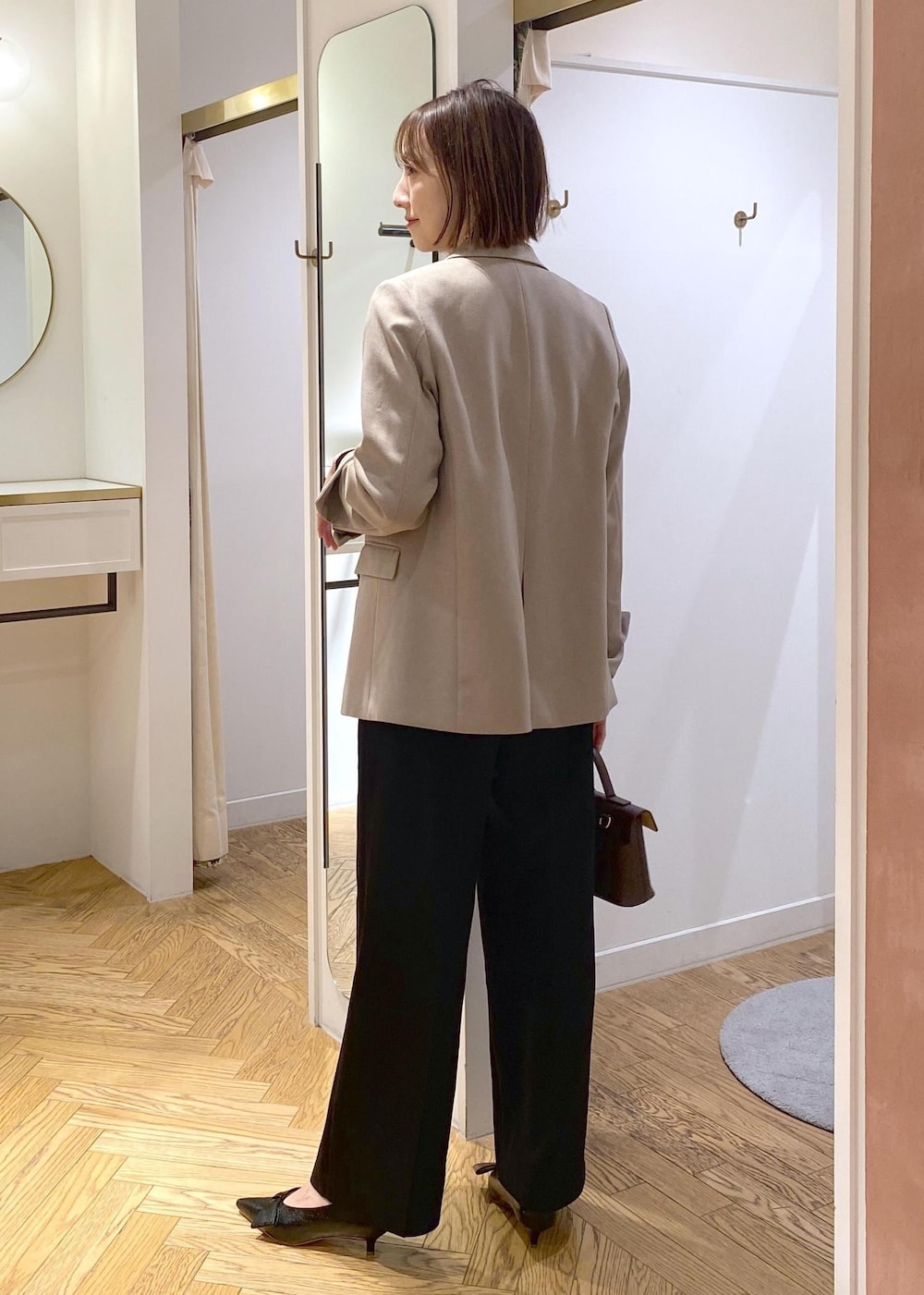 ブラック系のパンプス、ブラック系のニット/セーター、ブラック系のスラックスを着用したレディースの冬コーディネートの5枚目の写真