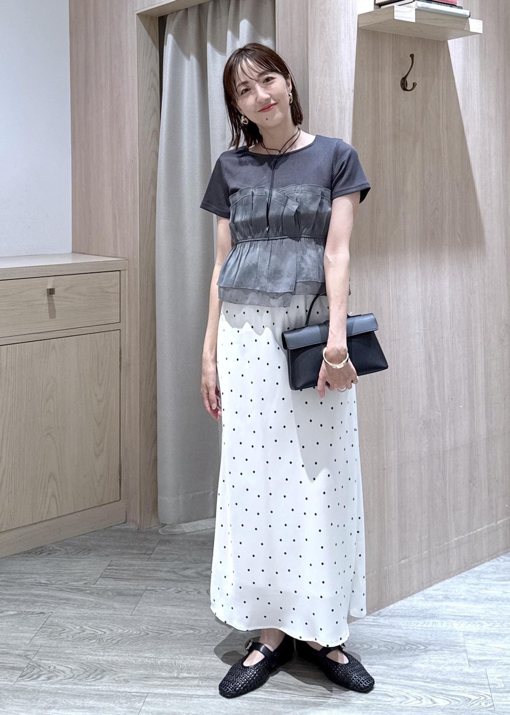 ブラック系のショルダーバッグ、ブラック系のTシャツ/カットソー、ブラック系のパンプスを着用したレディースの夏コーディネートの2枚目の写真