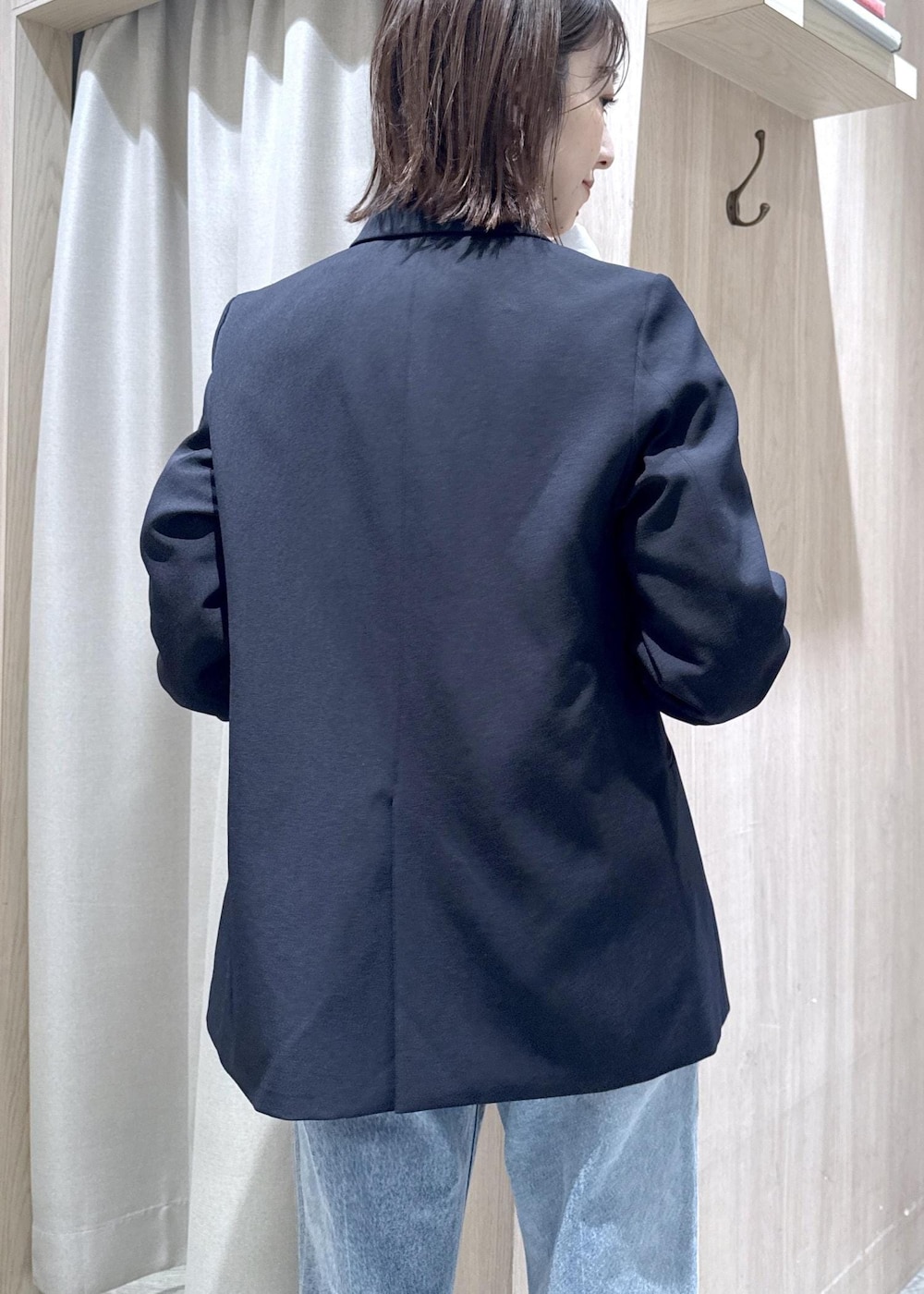 ブルー系のテーラードジャケット、ブラック系のショルダーバッグ、ブルー系のデニムパンツを着用したレディースの冬コーディネートの5枚目の写真