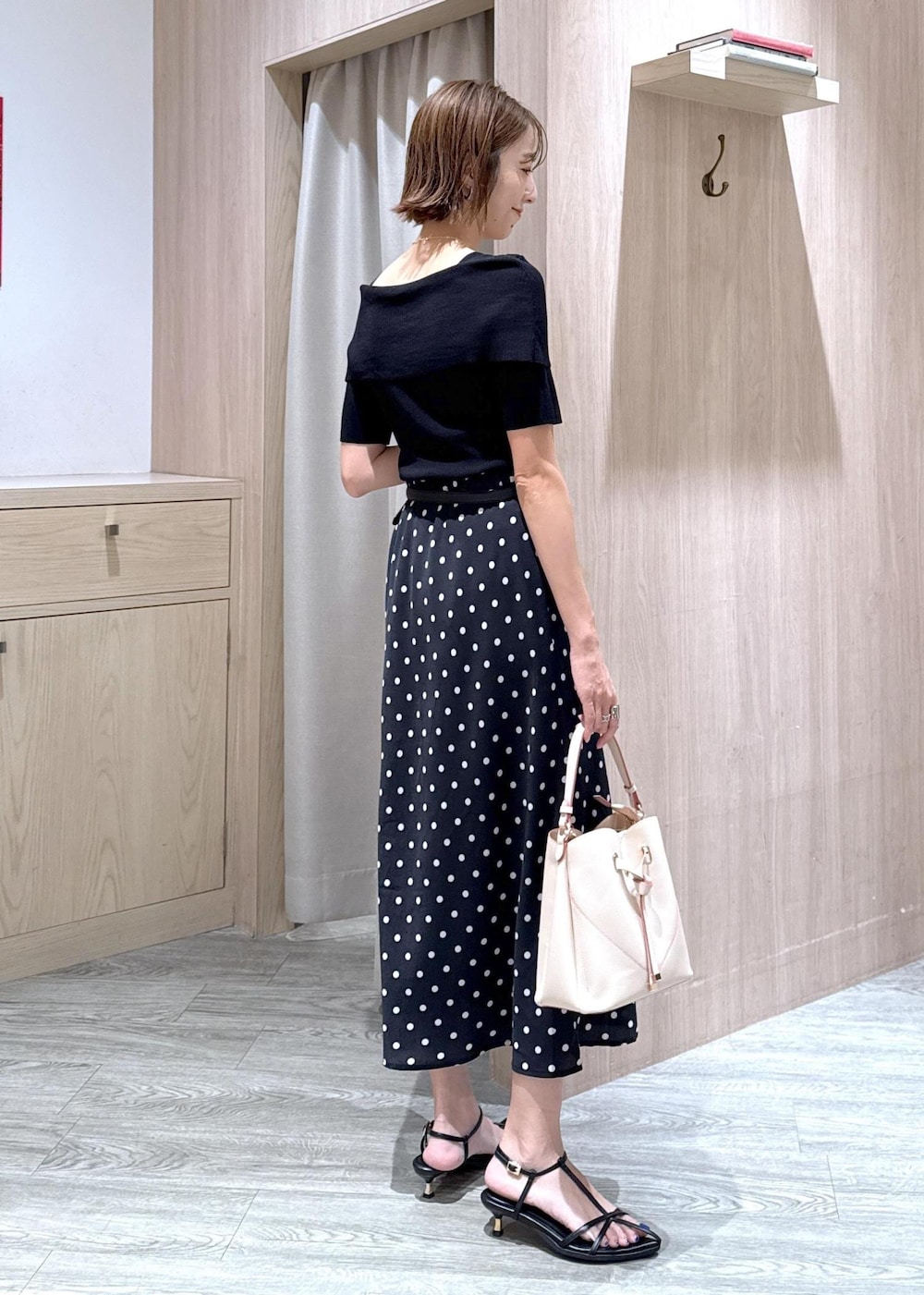ベージュ系のショルダーバッグ、ブラック系のサンダル、ブラック系のスカートを着用したレディースの夏コーディネートの4枚目の写真