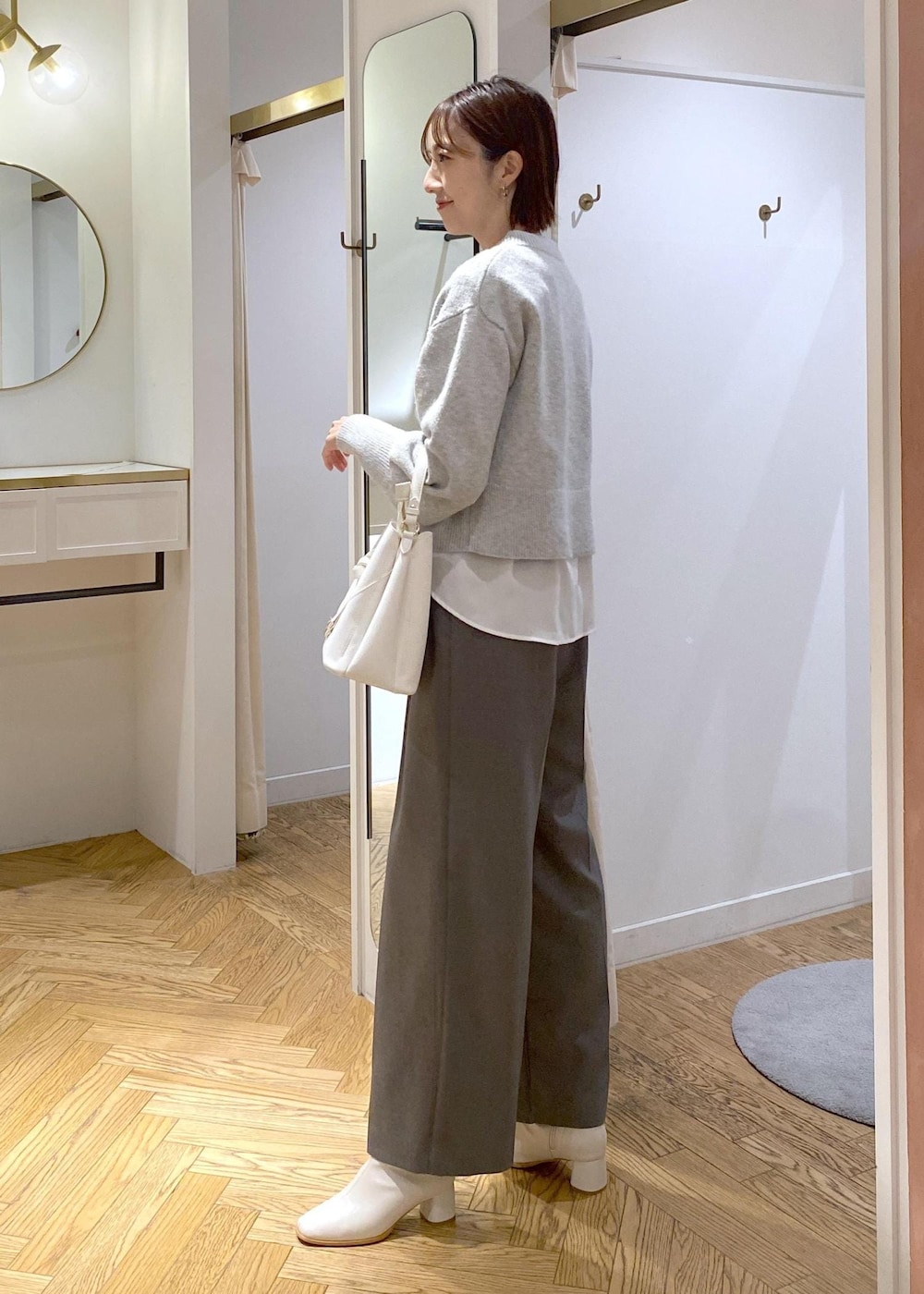 ホワイト系のブーツ、ホワイト系のシャツ/ブラウス、グレー系のカーディガン/ボレロを着用したレディースの冬コーディネートの4枚目の写真