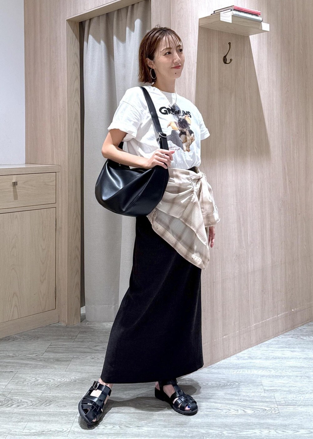 グレー系のスカート、ベージュ系のシャツ/ブラウス、ホワイト系のTシャツ/カットソーを着用したレディースの夏コーディネートの2枚目の写真