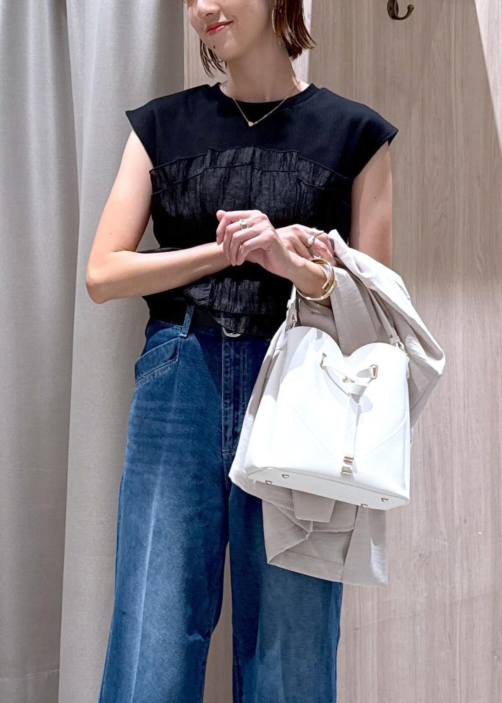 ホワイト系のショルダーバッグ、ブラック系のパンプス、ブラック系のTシャツ/カットソーを着用したレディースの夏コーディネートの6枚目の写真