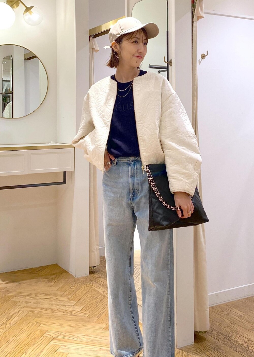 シルバー系のパンプス、ホワイト系のブルゾン、ブルー系のニット/セーターを着用したレディースの秋コーディネートの4枚目の写真