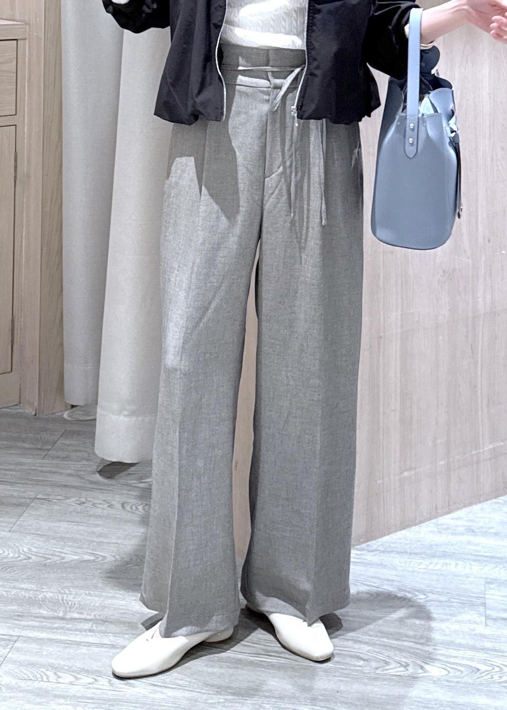 ブルー系のショルダーバッグ、ホワイト系のパンプス、ブラック系のブルゾンを着用したレディースの春コーディネートの6枚目の写真