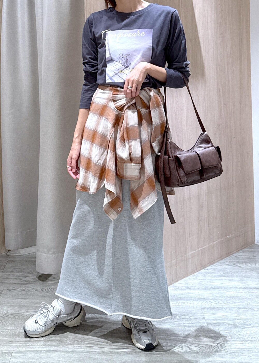 グレー系のスカート、ベージュ系のシャツ/ブラウス、グレー系のTシャツ/カットソーを着用したレディースの秋コーディネートの4枚目の写真