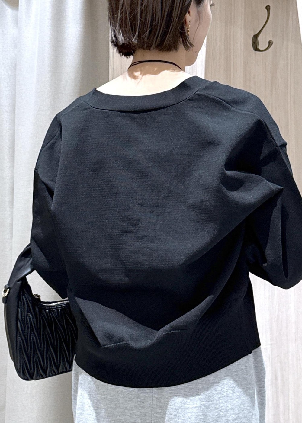 グレー系のスカート、ホワイト系のキャミソール、ブラック系のカーディガン/ボレロを着用したレディースの秋コーディネートの10枚目の写真