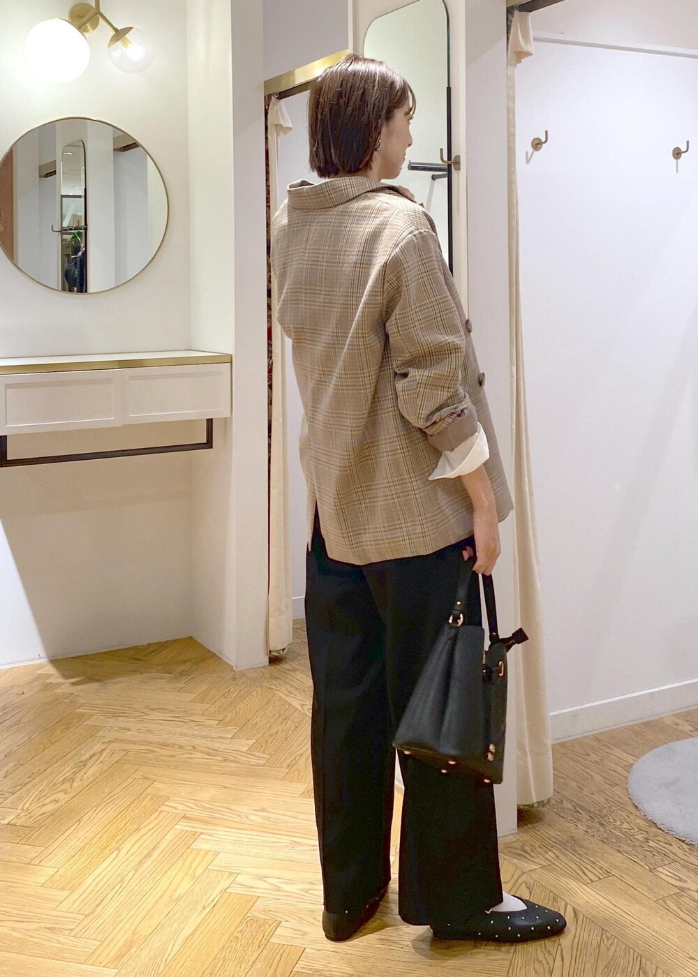 ブラック系のショルダーバッグ、ブラック系のバレエシューズ、ホワイト系のTシャツ/カットソーを着用したレディースの秋コーディネートの2枚目の写真