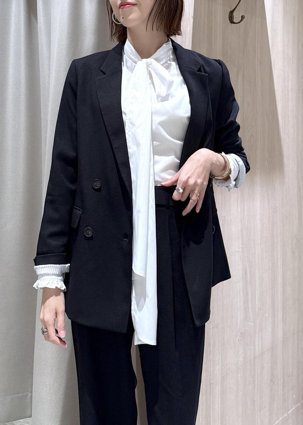 ブラック系のスラックス、ブラック系のテーラードジャケット、グレー系のその他アウターを着用したレディースの冬コーディネートの4枚目の写真