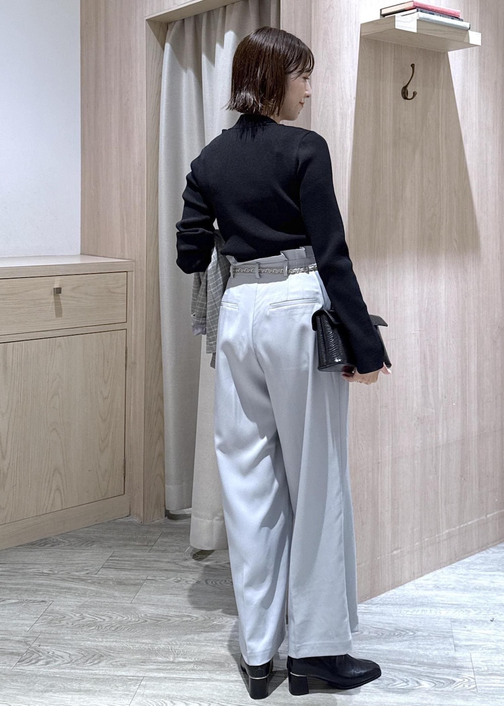 ブルー系のその他パンツ、グレー系のテーラードジャケット、ブラック系のハンドバッグを着用したレディースの秋コーディネートの3枚目の写真