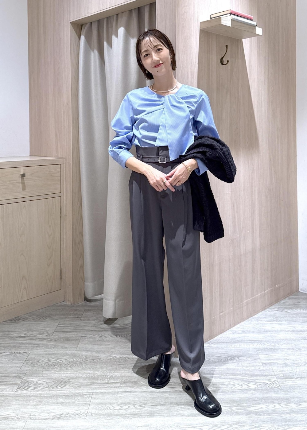 ブラック系のハンドバッグ、ブルー系のカーディガン/ボレロ、グレー系のその他パンツを着用したレディースの秋コーディネートの9枚目の写真