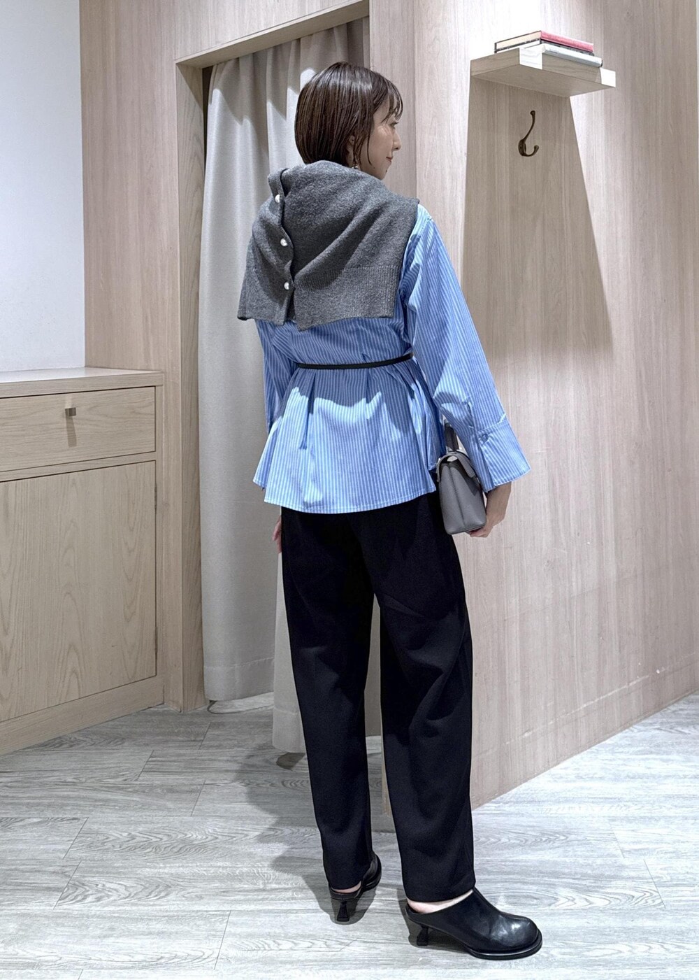 グレー系のショルダーバッグ、ブラック系のスラックス、グレー系のカーディガン/ボレロを着用したレディースの秋コーディネートの6枚目の写真