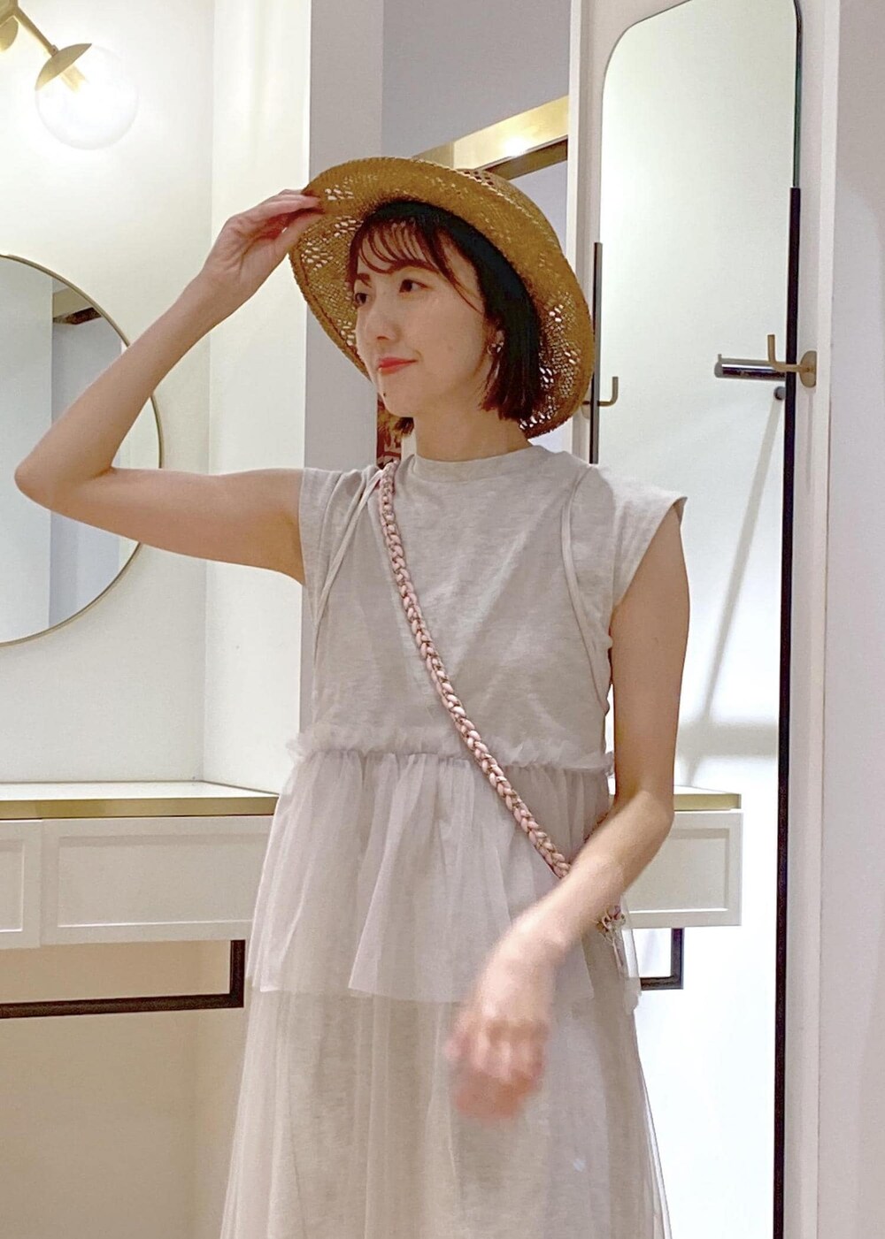 ブラック系のキャミソール、シルバー系のトートバッグ、ホワイト系のワンピースを着用したレディースの春コーディネートの5枚目の写真