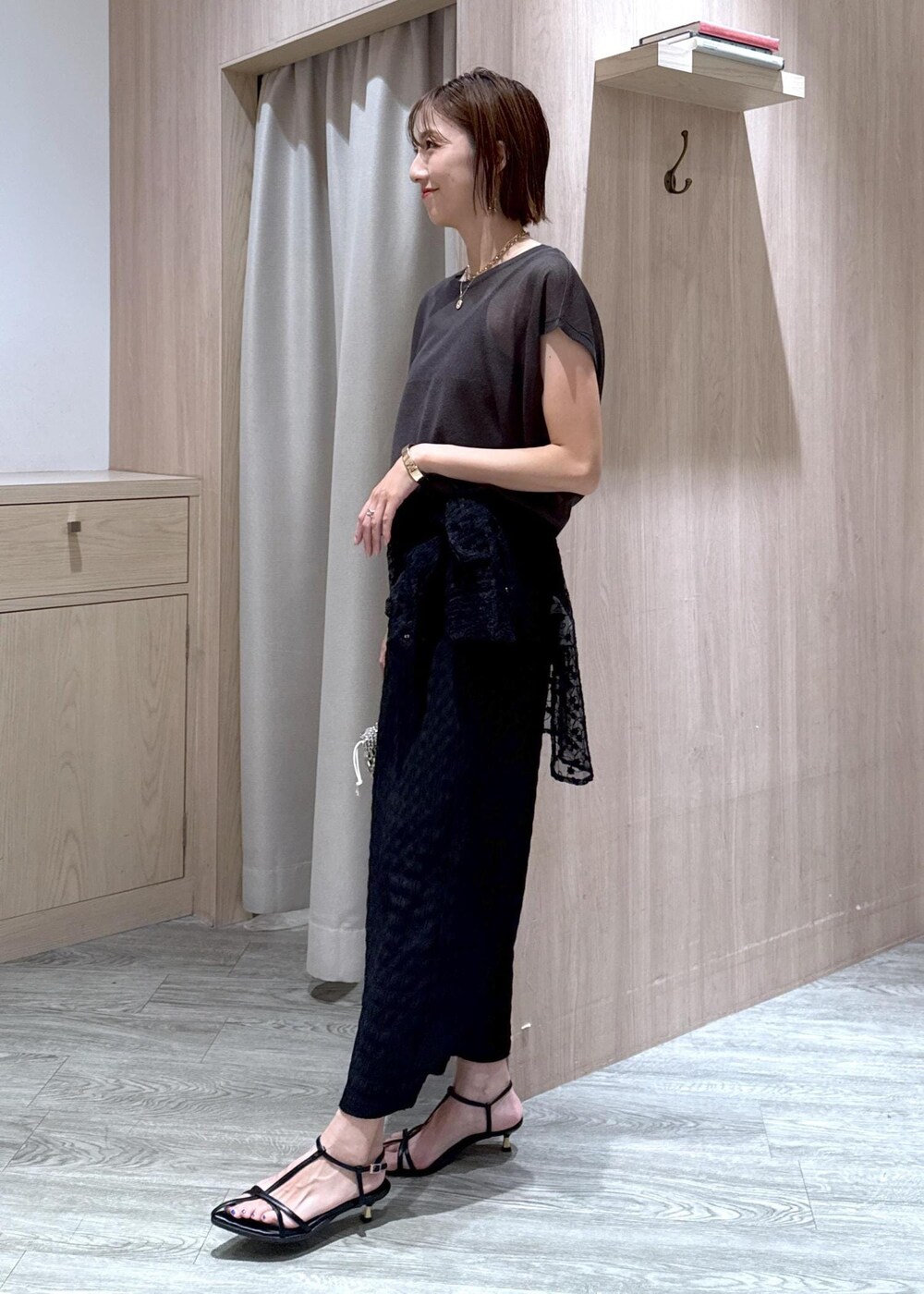 ブラック系のサンダル、シルバー系のハンドバッグ、ブラック系のシャツ/ブラウスを着用したレディースの夏コーディネートの3枚目の写真