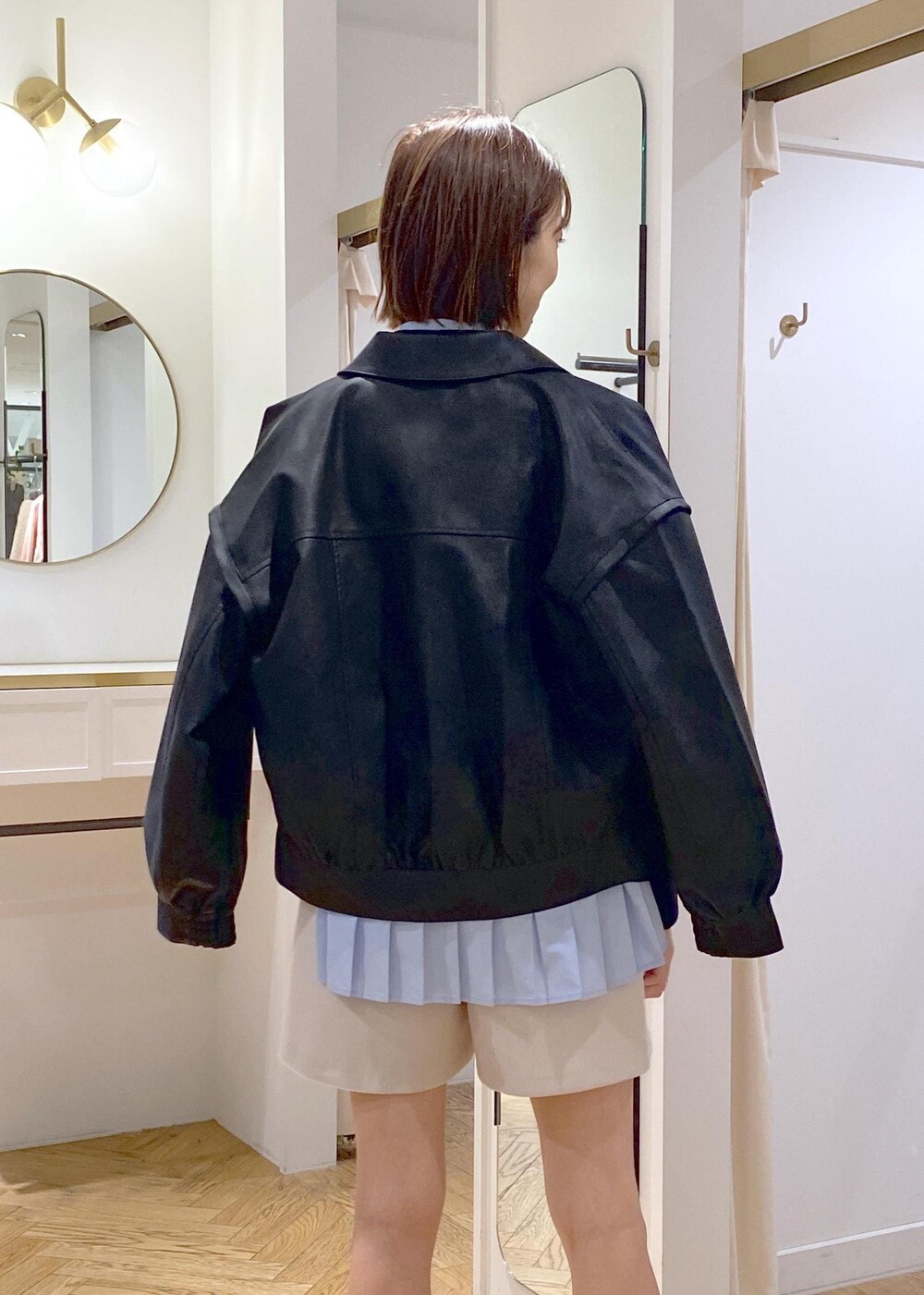 ブルー系のシャツ/ブラウス、ブラック系のブーツ、ブラック系のブルゾンを着用したレディースの秋コーディネートの4枚目の写真