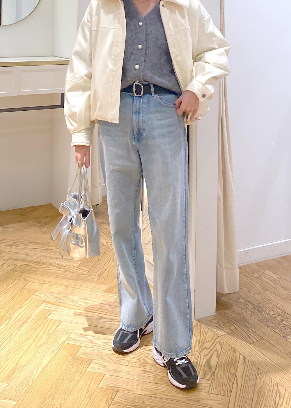 シルバー系のショルダーバッグ、ブルー系のデニムパンツ、グレー系のカーディガン/ボレロを着用したレディースの冬コーディネートの6枚目の写真