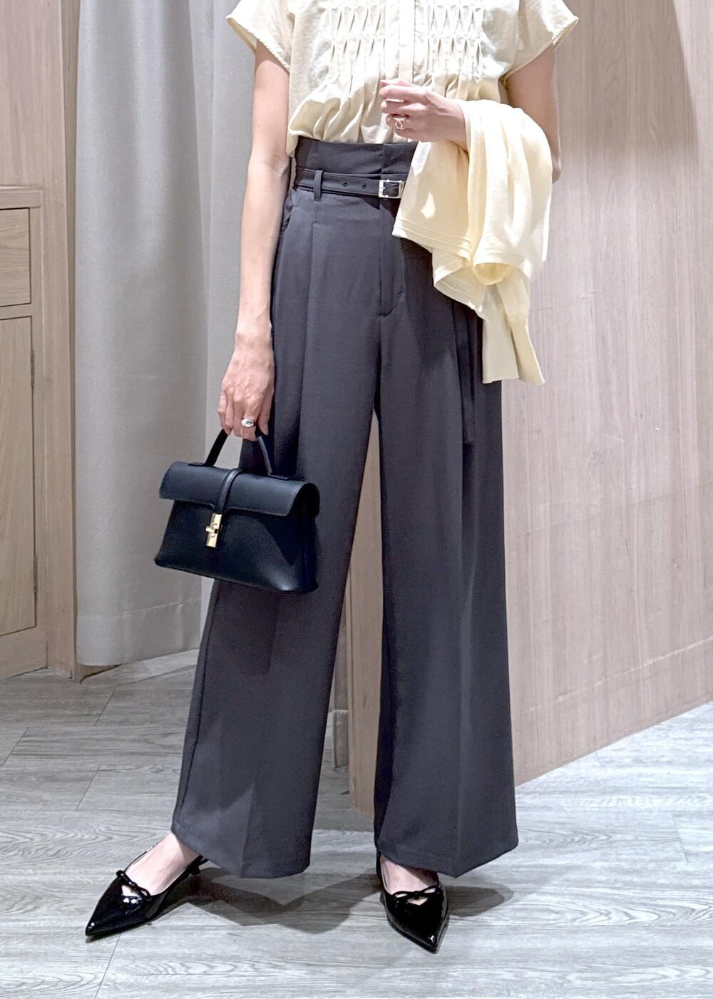 ブラック系のショルダーバッグ、ブラック系のパンプス、ホワイト系のカーディガン/ボレロを着用したレディースの春コーディネートの4枚目の写真